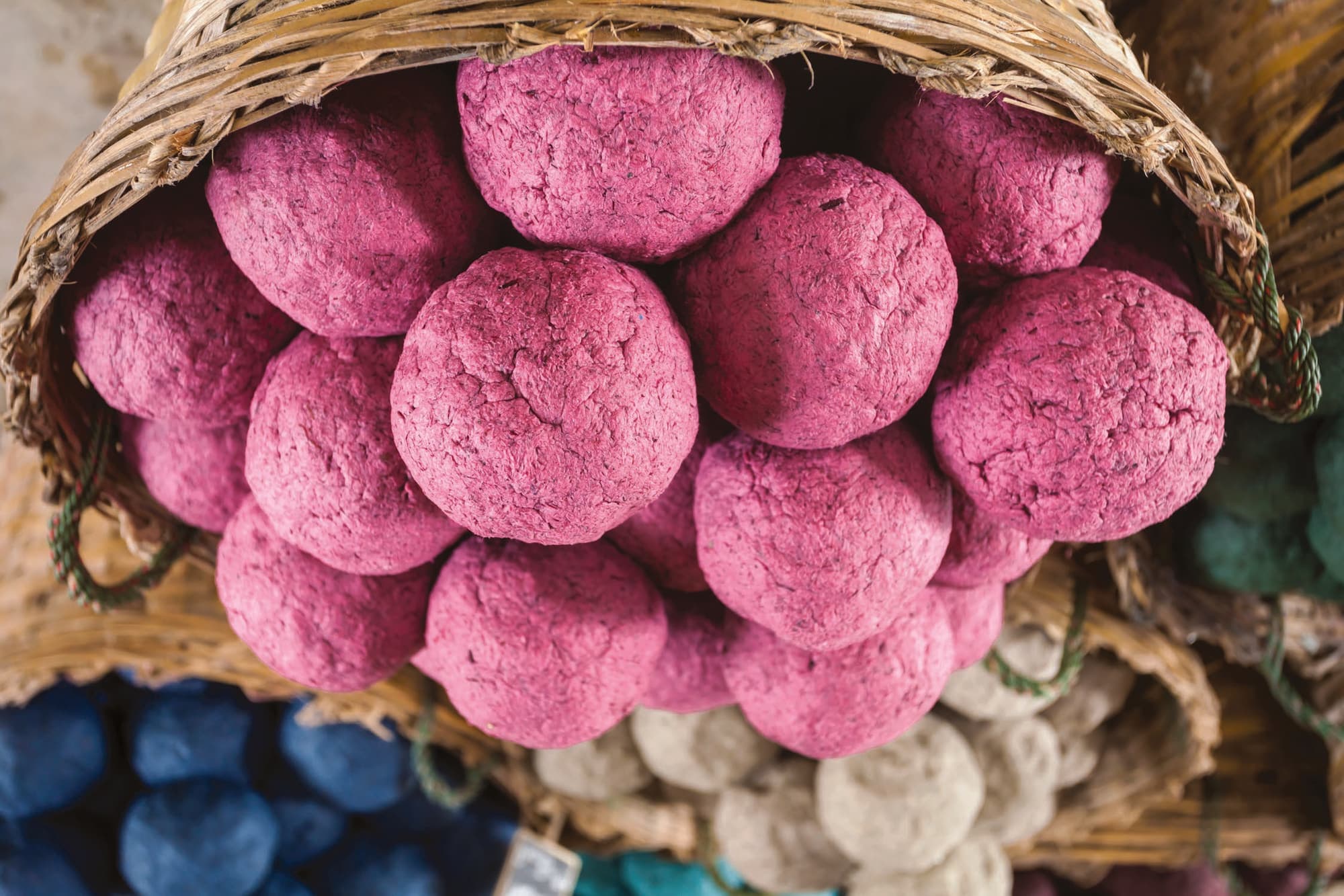 A basket of pink herbal vitamin balls made for the elephants