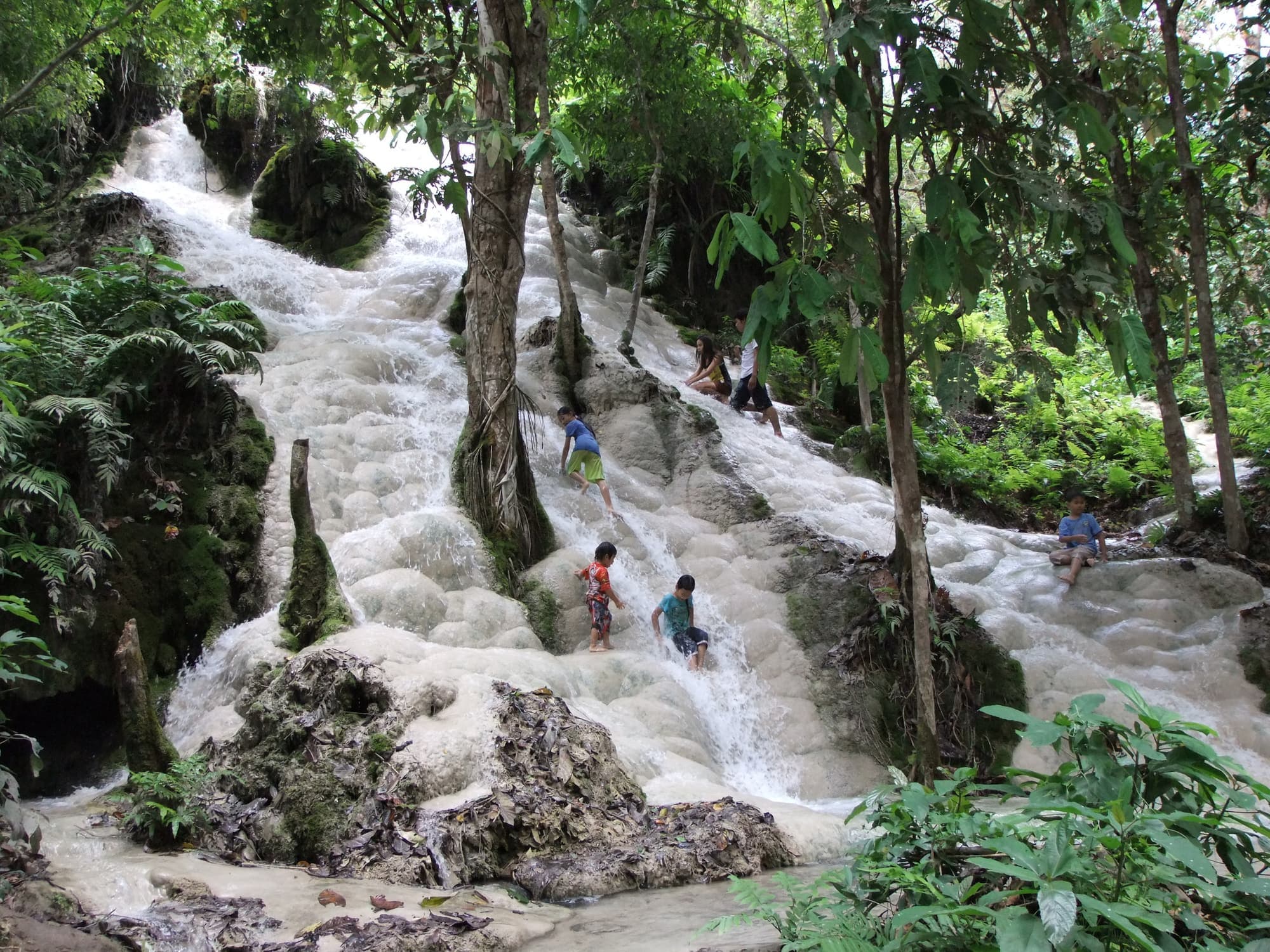 Visitors climbing the limestone cascades of Bua Tong Sticky Waterfall